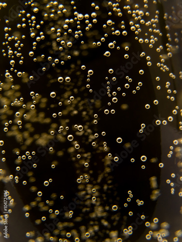 Foto: Macro of sparkling champagne against black background. Macro of sparkling champagne against black background.