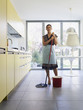 Young woman with mop in kitchen Young woman with mop in kitchen
