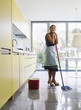 Young woman daydreaming, holding mop Young woman daydreaming, holding mop