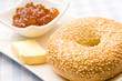 Fresh bagel with jam and butter on a plate