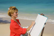 A female artist painting on the beach in Hawaii