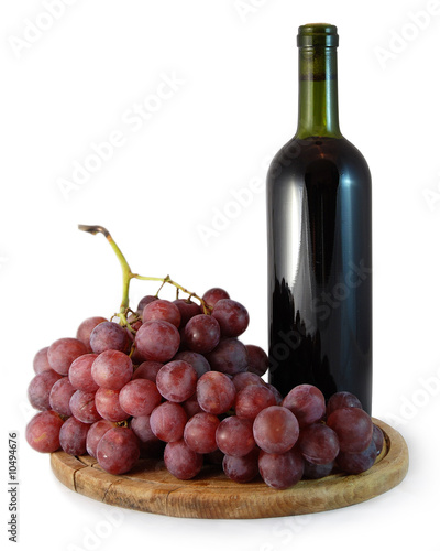 Photo: bottle of red wine and a bunch of red grapes on white background bottle of red wine and a bunch of red grapes on white background