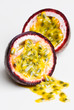 A passionfruit split in half with the seeds falling out.
