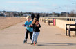 Young brother and sister scooting along a beach