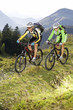 Austria, Tirol, young couple riding bicycles on mountain