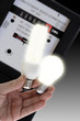 Energy saving lamp and electric bulb, electric meter in background, close-up