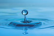 Water drop falling into water, close-up