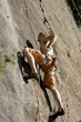 Young man rock climbing, low angle view