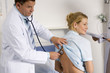 Doctor auscultating female patient