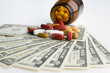 Photo: Prescription bottle and pills on US banknotes, close-up Prescription bottle and pills on US banknotes, close-up