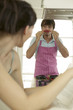 Young couple in kitchen, man holding chilli to nose