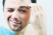 Young men pluck his eyebrows.