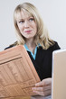 Businesswoman Reading Stock Listings in Newspaper