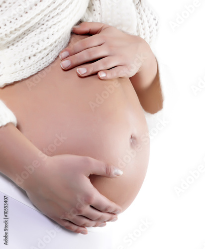 Foto: Image of pregnant woman touching her belly with hands Image of pregnant woman touching her belly with hands