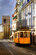 View of an old Lisbon street with the traditional yellow tram View of an old Lisbon street with the traditional yellow tram