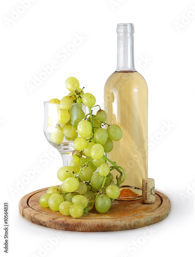 Photo: bottle of white wine and grapes in a glass on white background bottle of white wine and grapes in a glass on white background