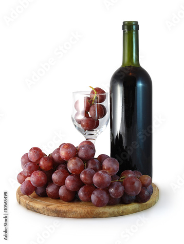 Photo: bottle of red whine and glass with red grapes in it bottle of red whine and glass with red grapes in it