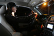 Beautiful young woman driving car at night