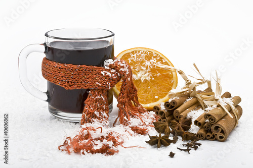 Foto: cup of hot wine and spicery covered with snow cup of hot wine and spicery covered with snow
