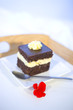 Delicious cake on the white tray with red flower
