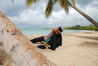 Homme en costume se reposant à l'ombre des cocotiers Homme en costume se reposant à l'ombre des cocotiers