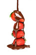 Foto: Pouring melted chocolate over four strawberries Pouring melted chocolate over four strawberries