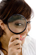 front view of smiling female holding magnifier close to eye front view of smiling female holding magnifier close to eye
