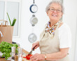 Lifestyle - Woman smiling and chopping tomatoes Lifestyle - Woman smiling and chopping tomatoes
