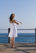 young woman play violin on beach pier young woman play violin on beach pier