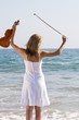 freedom of a young female violinist on beach