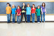 Photo: Portrait of students standing in a classroom with blackboard in Portrait of students standing in a classroom with blackboard in