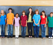 Photo: Portrait of students standing in a classroom with blackboard in Portrait of students standing in a classroom with blackboard in