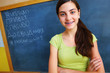 Photo: Beautiful young girl with blackboard in background Beautiful young girl with blackboard in background