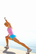 Foto: Woman exercising by the sea on a sunny day Woman exercising by the sea on a sunny day