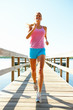 Woman jogging by the sea on a pier