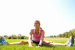 Foto: Happy woman exercising on a grassy land Happy woman exercising on a grassy land