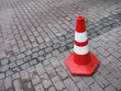 A traffic cone on a cobbled road