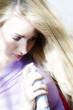 Portrait of a young woman using hair spray