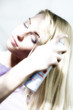 Portrait of a young woman using hair spray