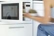Woman using a microwave, close-up