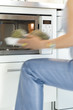 Woman using a microwave, close-up