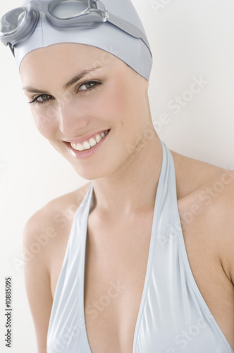 Portrait of a young smiling woman with bikini, swimming cap and goggles Portrait of a young smiling woman with bikini, swimming cap and goggles