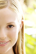 Photo: Portrait of half of a young woman's face, smiling, looking at the camera, close-up, outdoors Portrait of half of a young woman's face, smiling, looking at the camera, close-up, outdoors