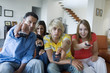 Parents and 2 teens using remote-controls
