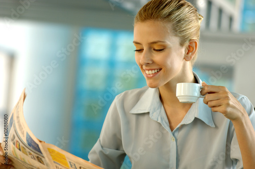 Foto: Businesswoman reading newspaper, smiling Businesswoman reading newspaper, smiling