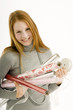 Portrait of a young woman holding rolls of wrapping papers and smiling