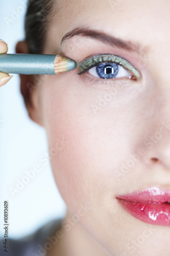 Photo: Young woman applying eyeliner Young woman applying eyeliner