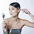 woman combing her hair with a silver fork