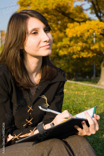 Photo: The girl writes a diary on fresh air The girl writes a diary on fresh air