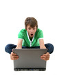 Boy looking angry whilst holding computer Boy looking angry whilst holding computer